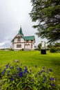 View from the park at wooden Church in Husavik town in Nordurting municipality on the North coast of Iceland. Blue flowers are at